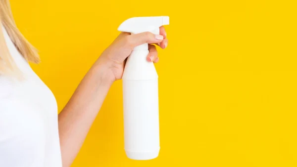 Prijssticker verwijderen reinigingsspray hand vrouw