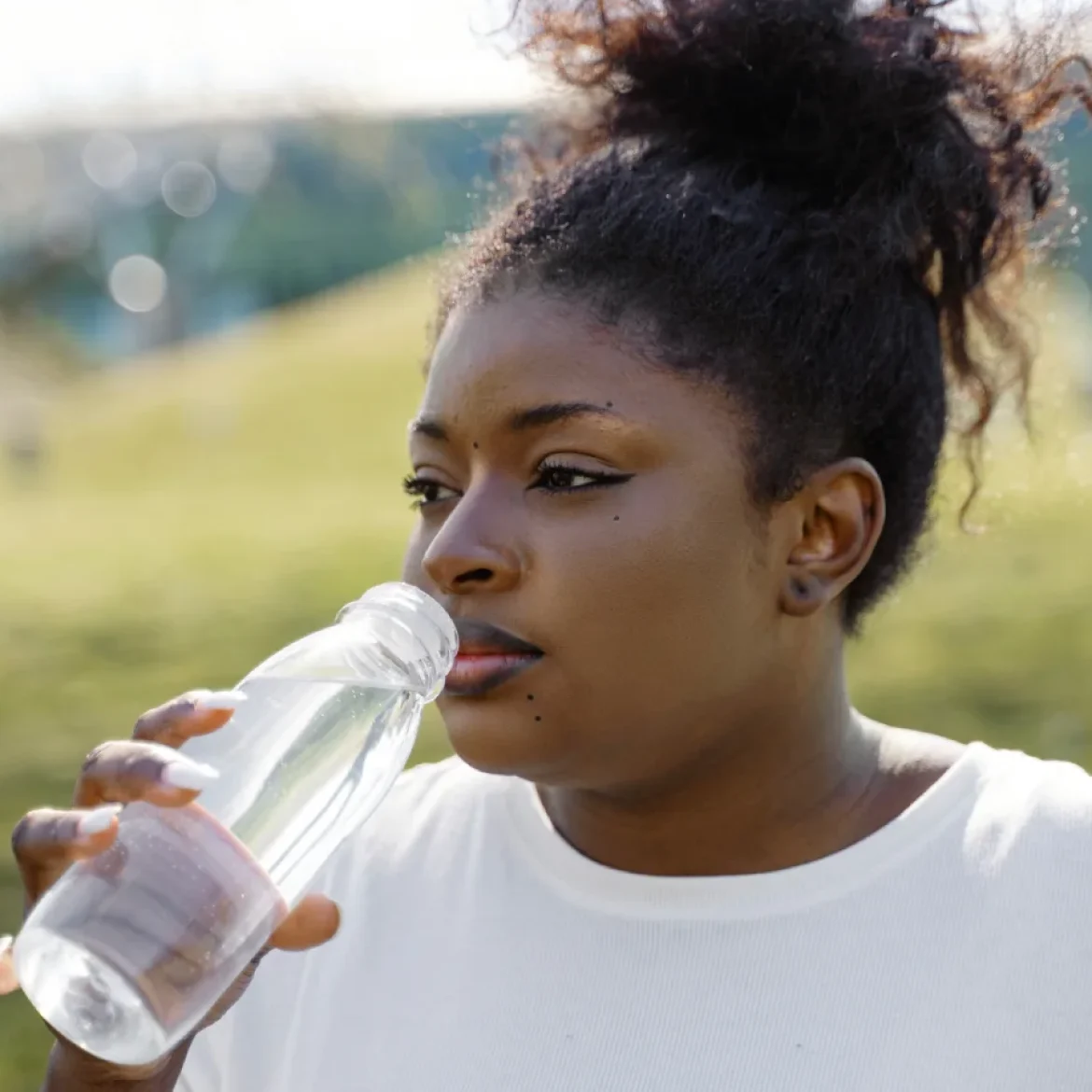 Vrouw drinkt water uit een plastic fles