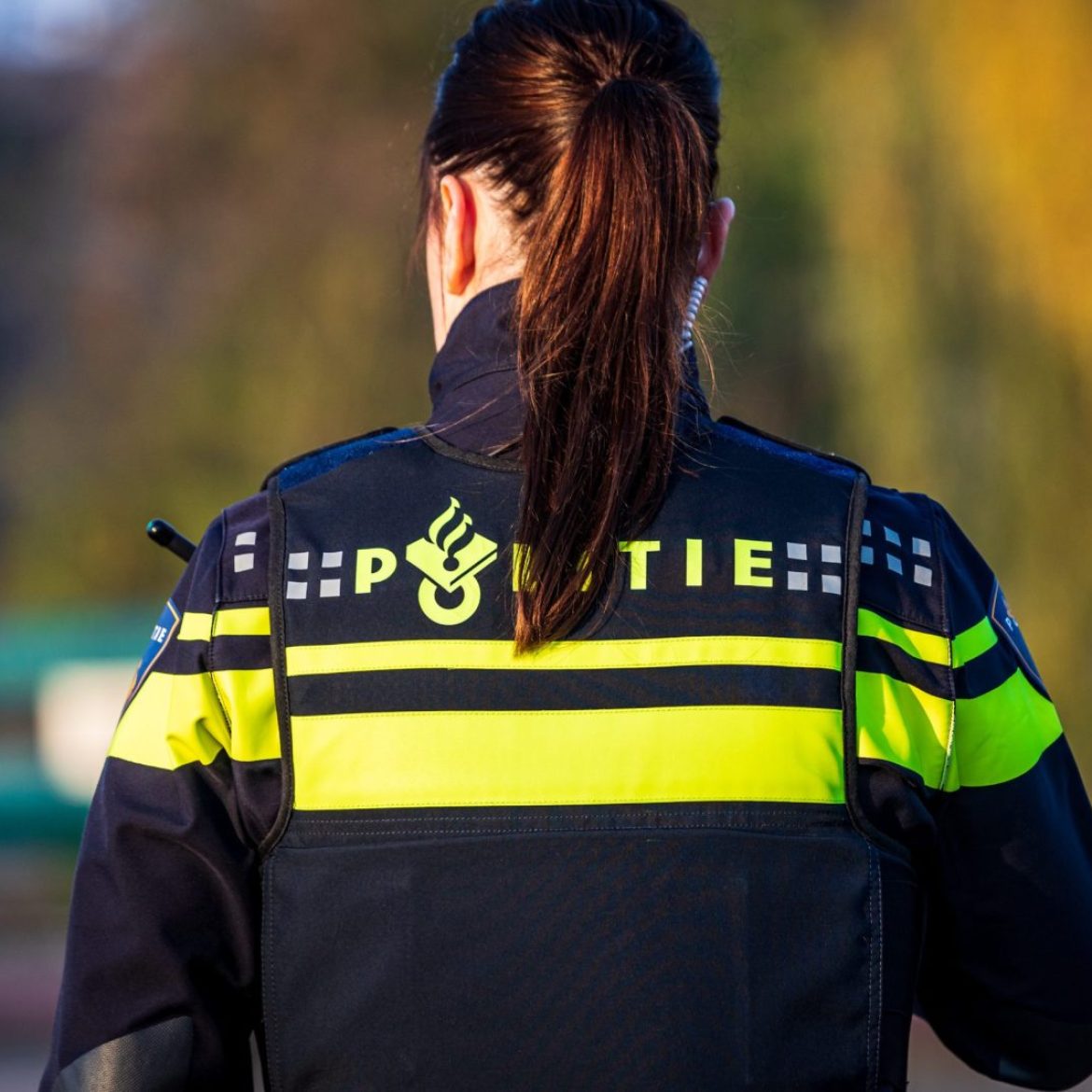 Foto van een vrouw van de politie, gezien vanaf de achterkant