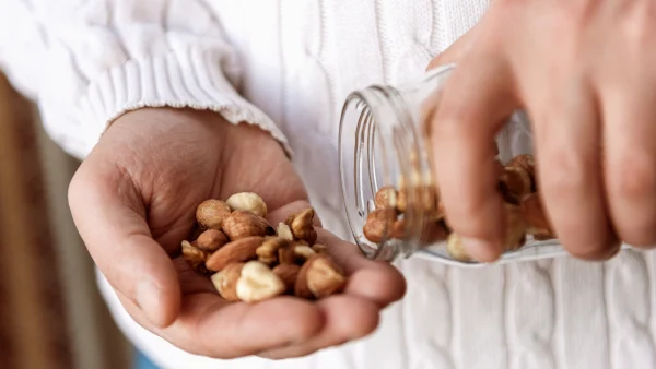 Man staat met nootjes in zijn hand - Mannen kunnen meedoen aan No Nu November