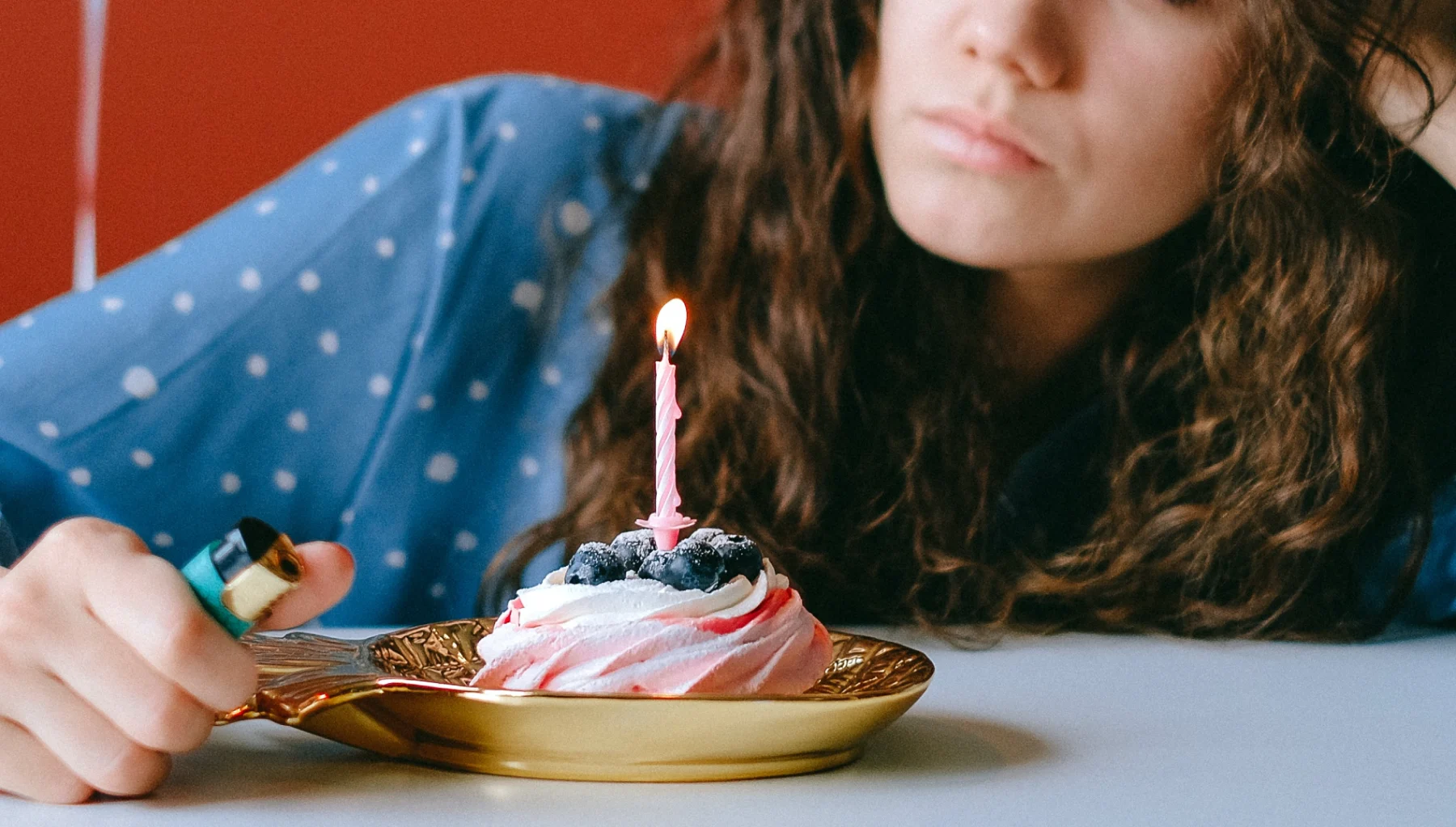 vrouw zit eenzaam voor een cupcake op haar verjaardag