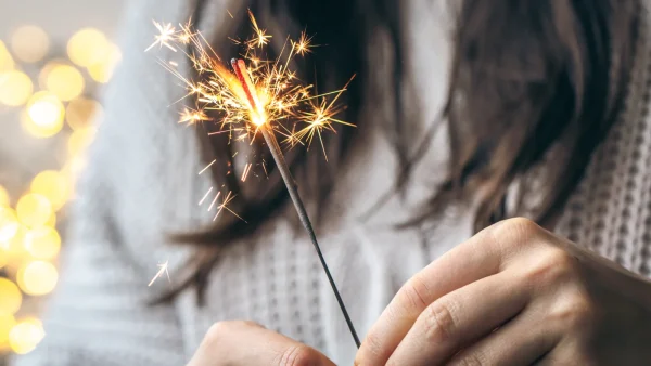 Vrouw houdt sterretje vast en is alleen met oud en nieuw