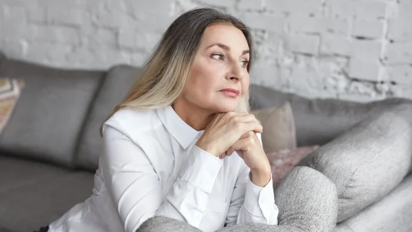 Vrouw kijkt peinzend voor zich uit