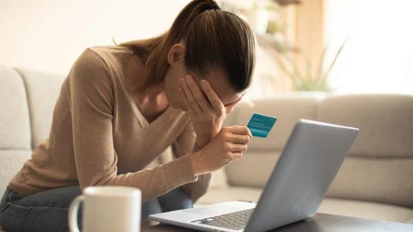 Vrouw houdt bankpas vast en baalt van bank fraude