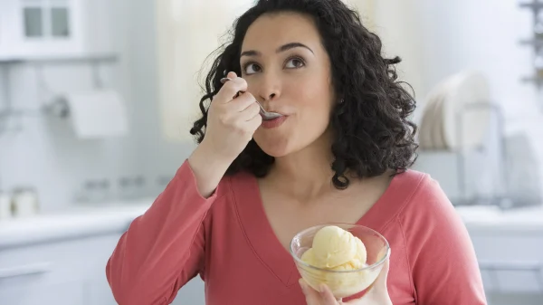 Vrouw eet ijs uit de vriezer