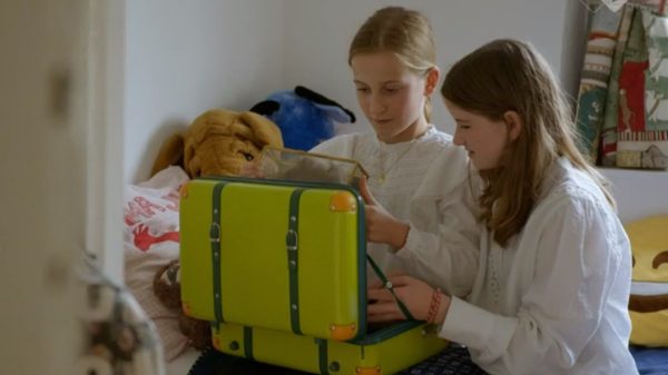 twee meisjes kijken naar spullen in koffer