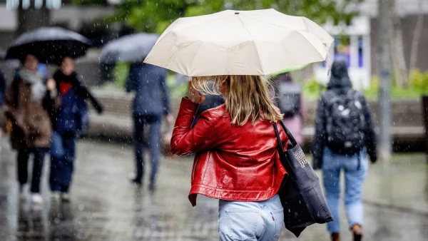 Vrouw loopt met paraplu in de regen