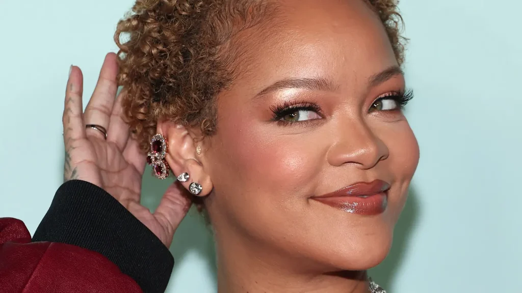 Zangeres en beauty ondernemer Rihanna lacht naar de camera bij Fenty Hair evenement