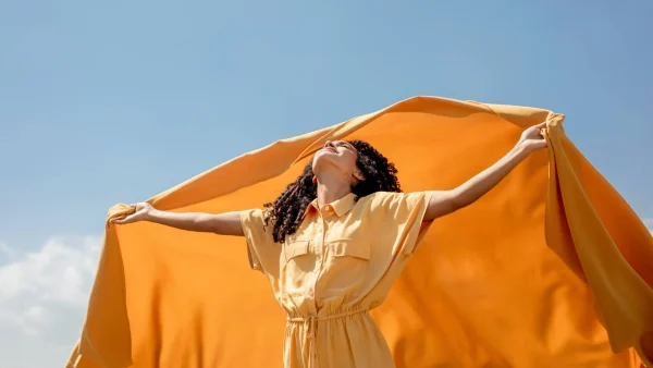 Vrouw in de zon met oranje doek