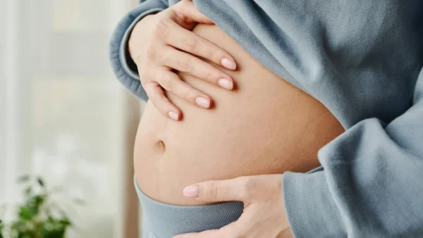 Vrouw heeft handen op haar zwangere buik