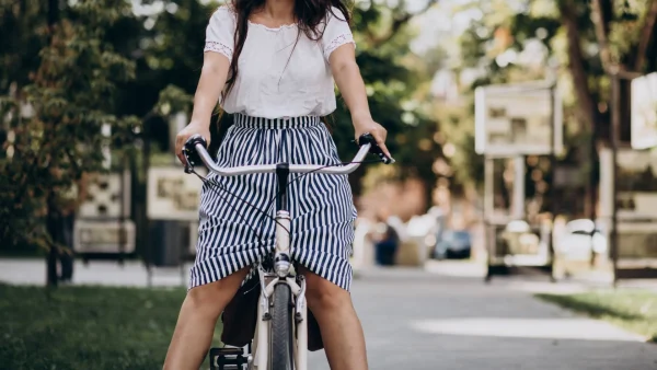 Vrouw aan het fietsen met lange jurk
