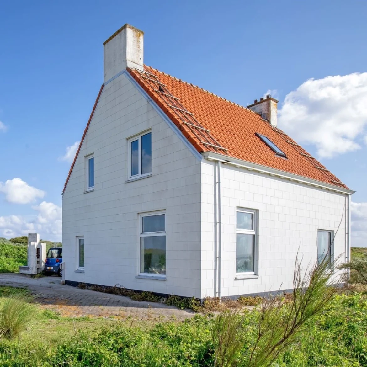 Wit huis op een groene vlakte naast de vuurtoren van Texel