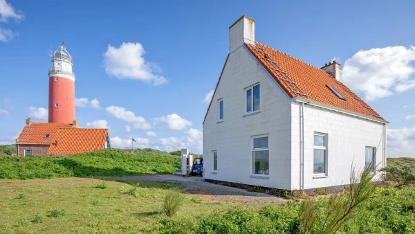 Wit huis op een groene vlakte naast de vuurtoren van Texel