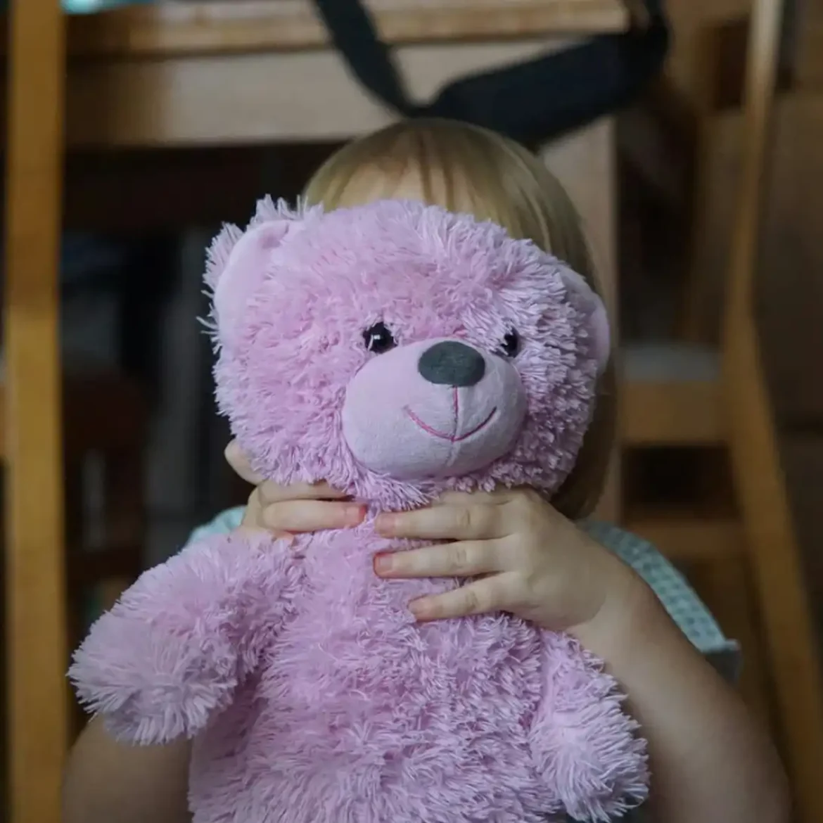 Klein meisje met een roze beer voor haar hoofd