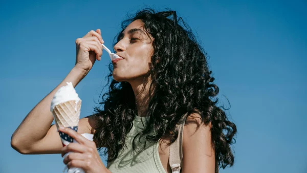 Vrouw eet een ijsje met zomers weer