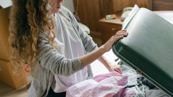 Vrouw pakt koffer in en gaat alleen op vakantie