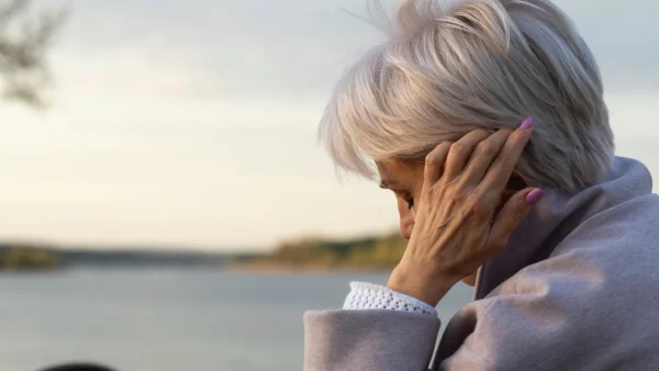 Vrouw Lorijn met hand in het haar aan het meer