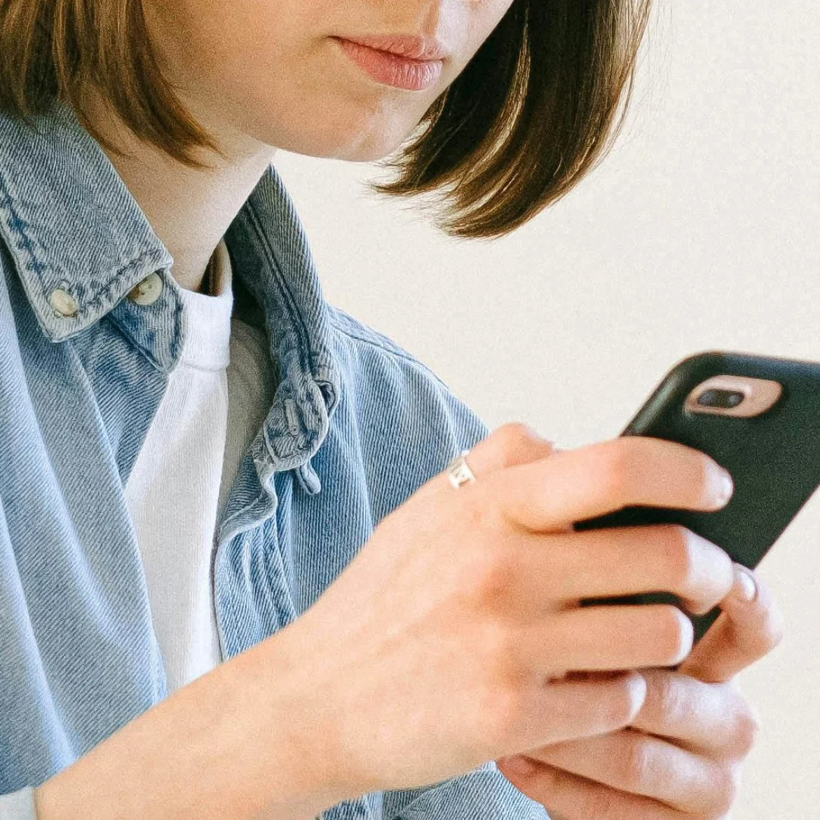 Vrouw kijkt naar mobiel in haar handen