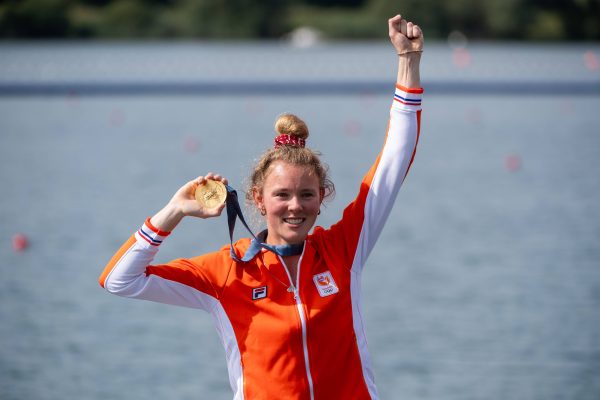 Karolien Florijn houdt haar gouden medaille omhoog.