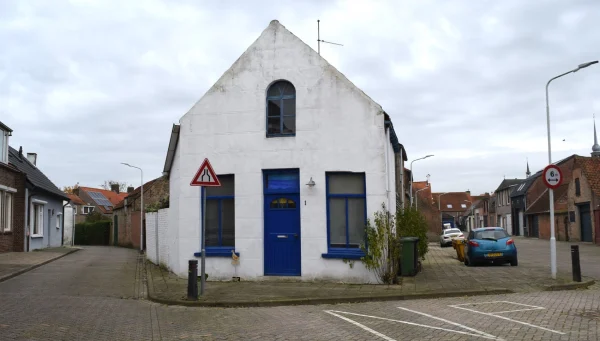 witte woning met blauwe voordeur