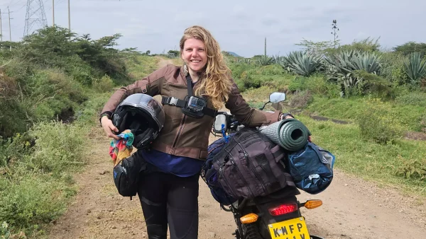 Tjalina staat in Afrika naast haar motor