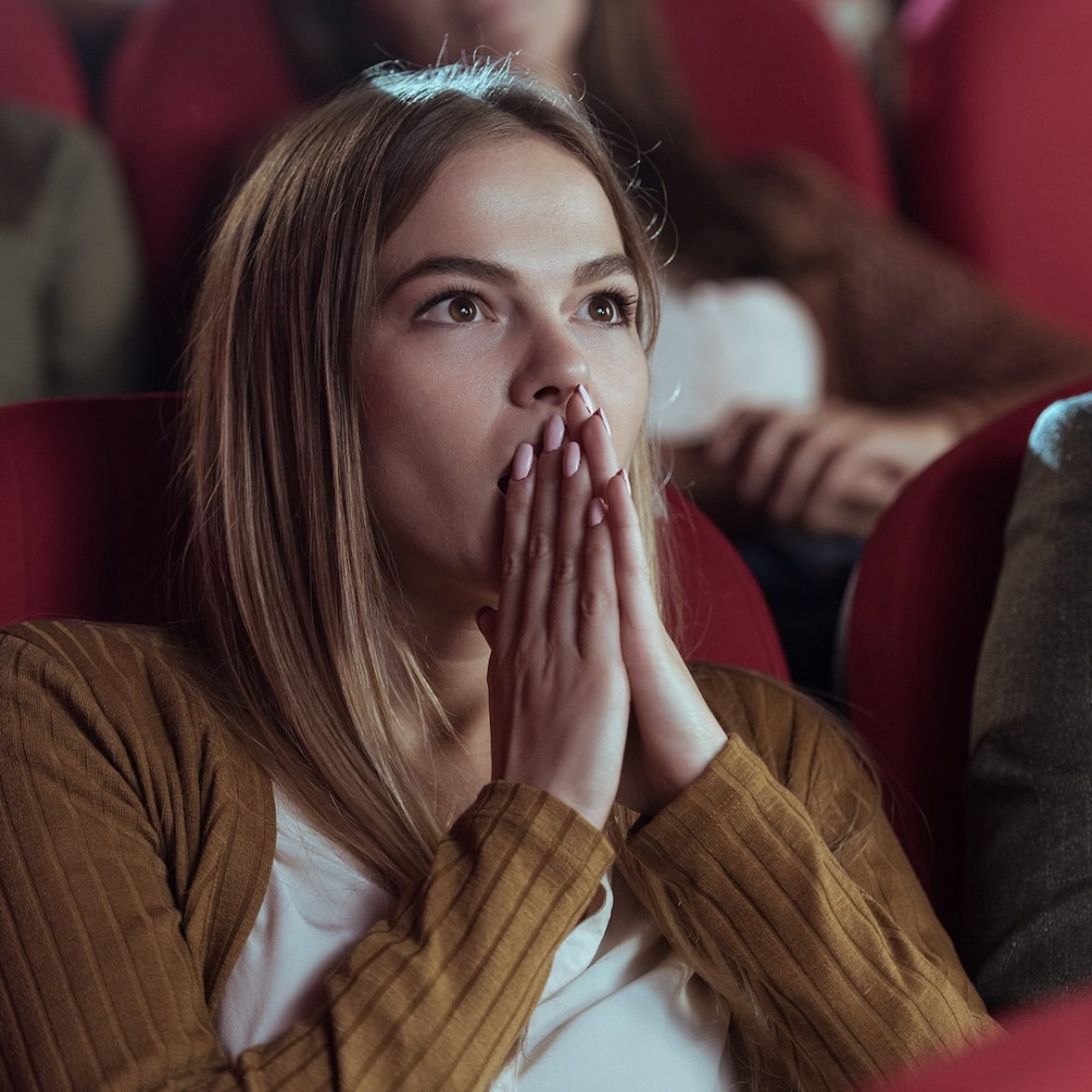 Meisje dat in de bioscoop kijkt naar een horrorfilm