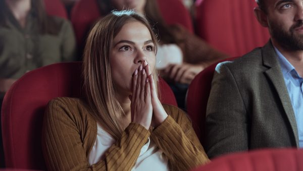 Meisje dat in de bioscoop kijkt naar een horrorfilm