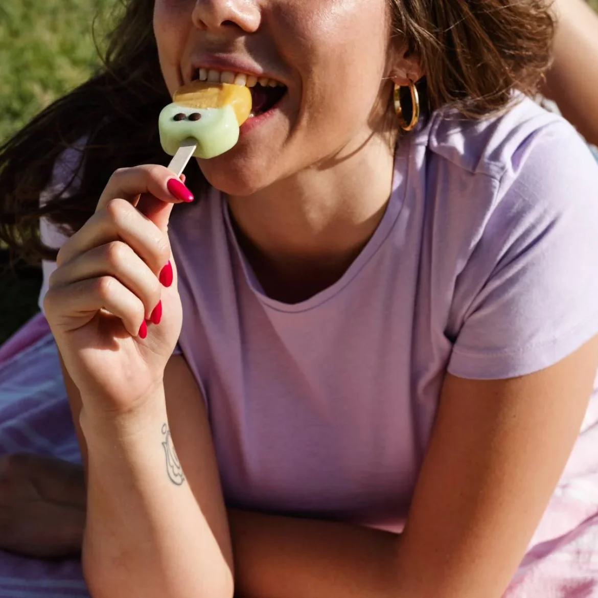 Vrouw eet ijsje in de zon met warm weer