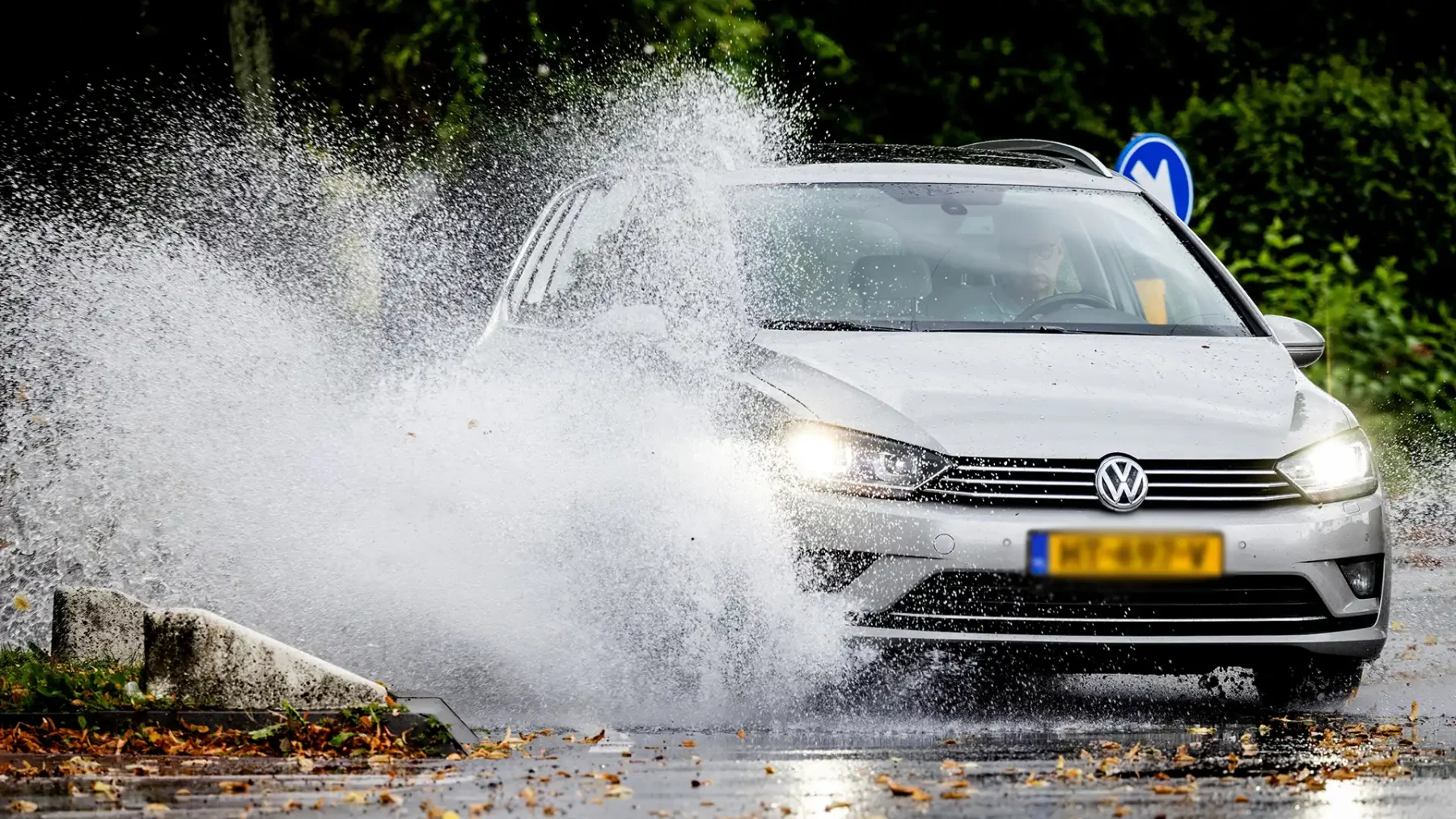 Auto rijdt door plas na hevige regen