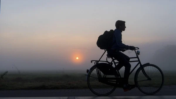 Jongen fiets in de dichte mist