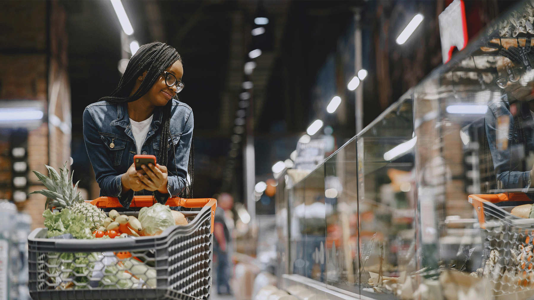 een vrouw in de supermarkt met fruit in haar kar