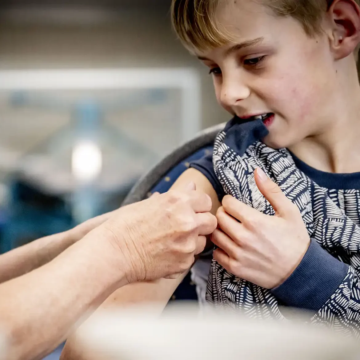 Kinderen krijgt vaccinatie door een medewerker van de GGD