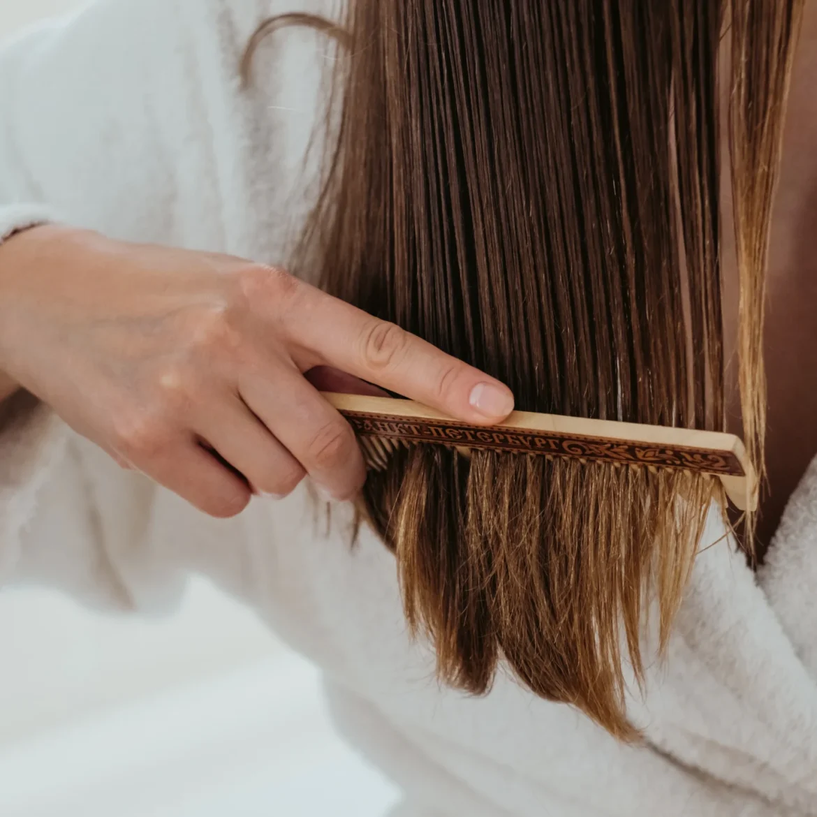 Vrouw kamt haar haren en heeft last van haaruitval