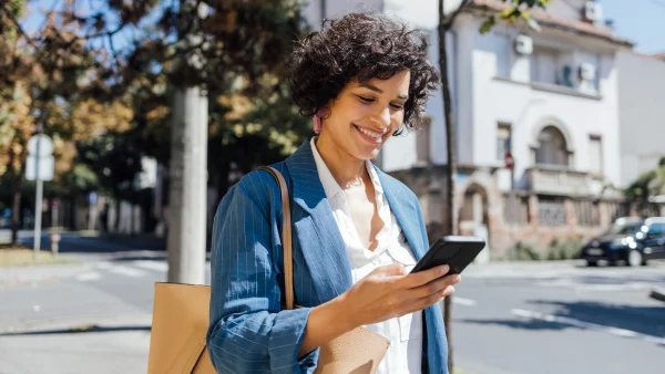 Vrouw kijkt blij naar telefoon