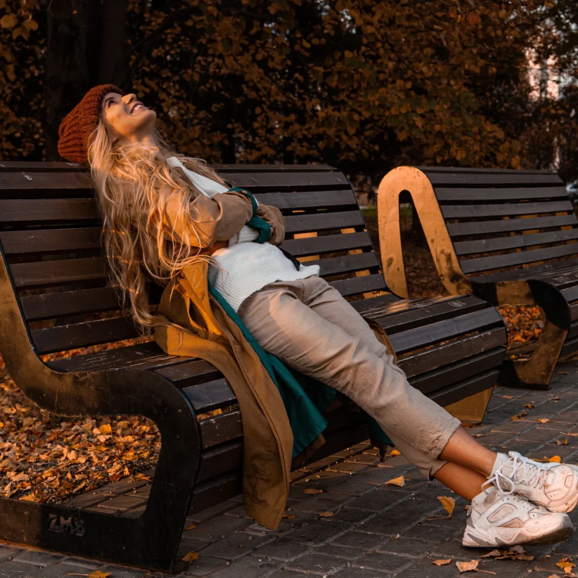 Vrouw in de herfst op bankje met sneakers