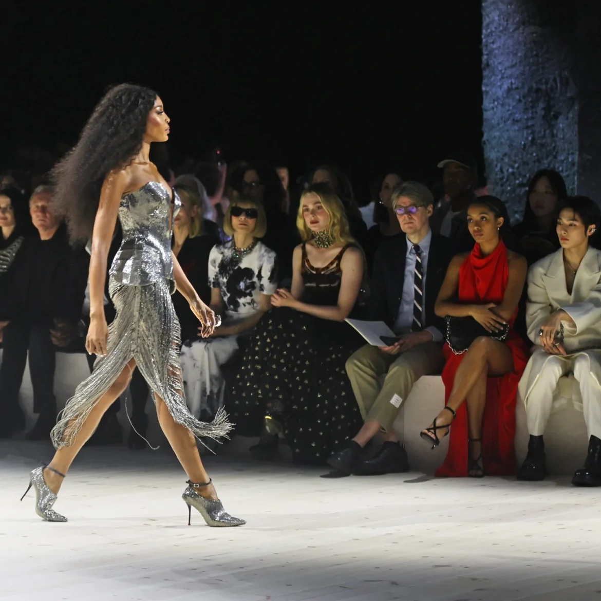 Model loopt op de catwalk en mensen kijken naar de laatste herfst mode