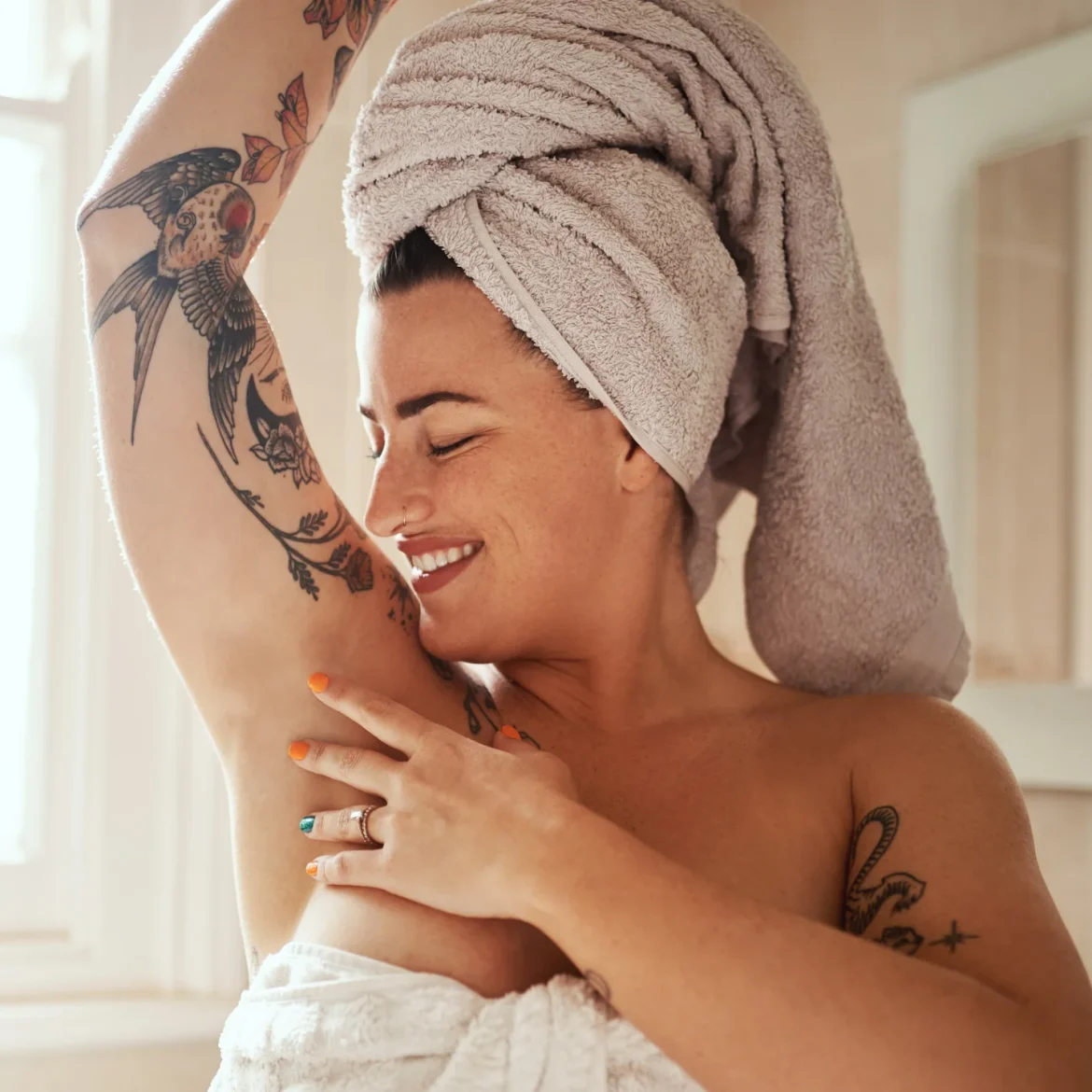 vrouw met tattoos in badkamer