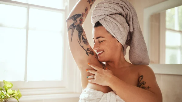 vrouw met tattoos in badkamer