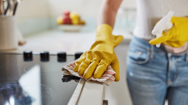 Persoon die keuken schoonmaakt met een vaatdoekje