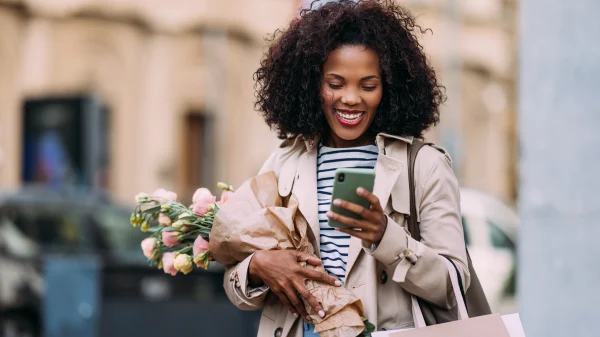 vrouw met bloemen en telefoon op straat herfst