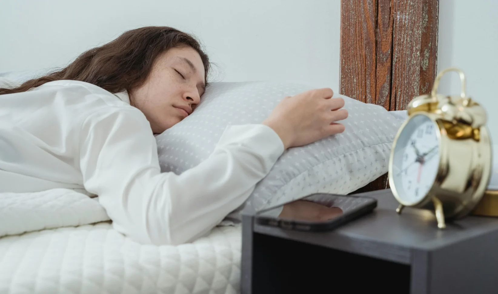 Vrouw die slaapt met een wekker naast haar