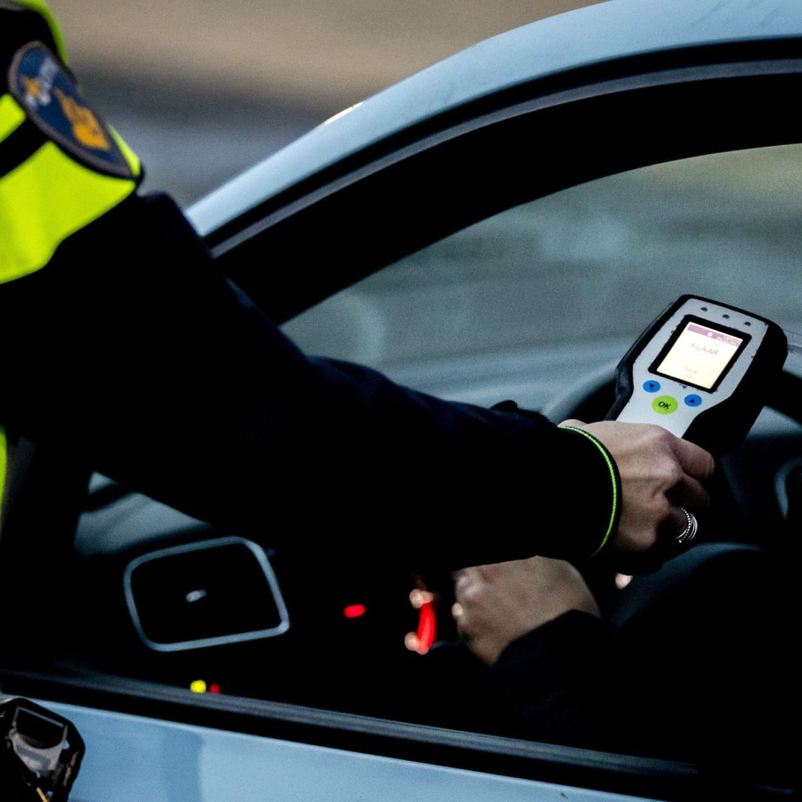 Vrouw met fles wijn in auto ANP