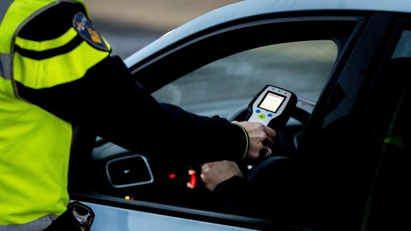 Vrouw met fles wijn in auto ANP