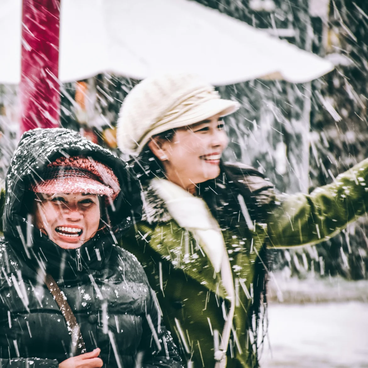 Twee vrouwen lachen in de sneeuw