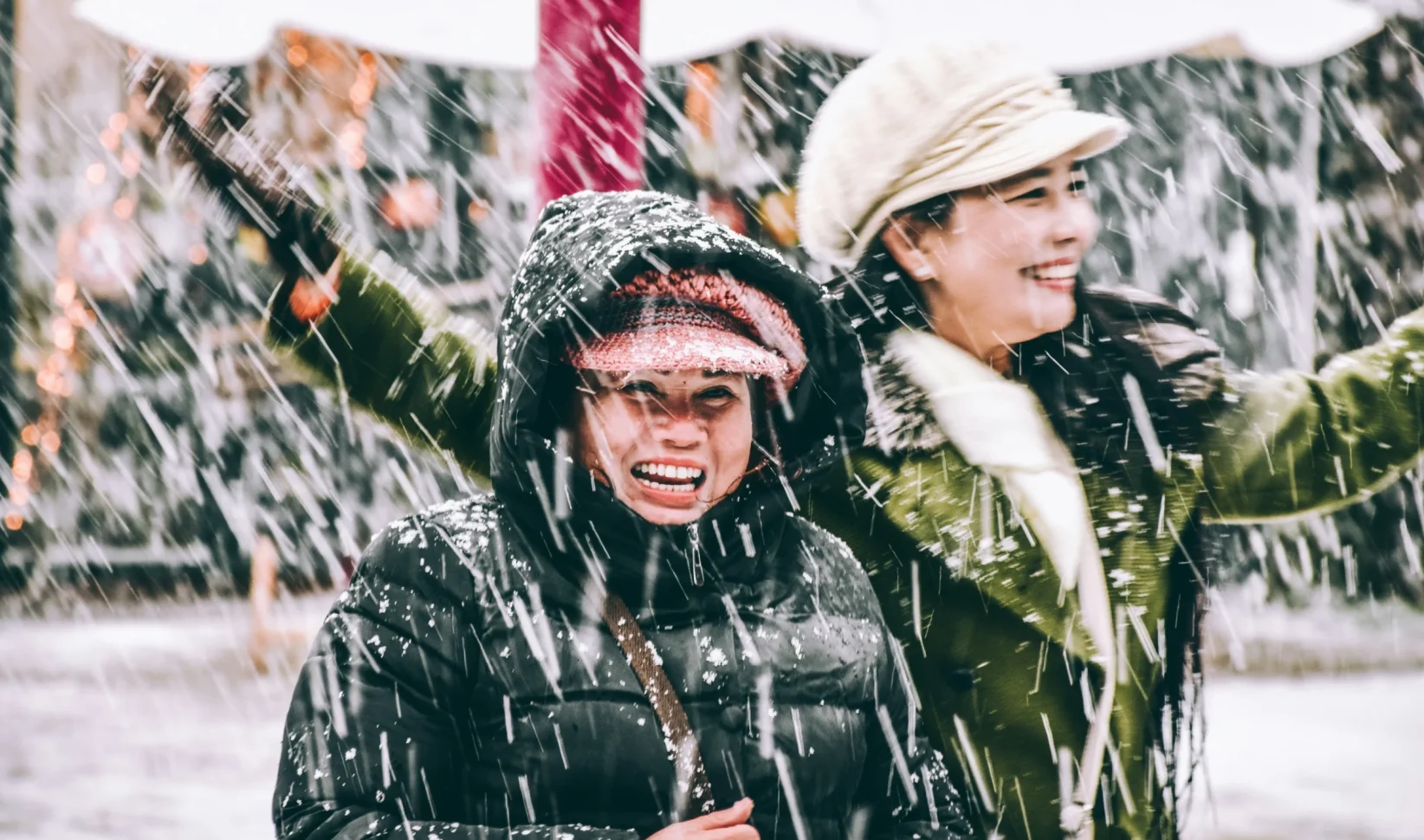 Twee vrouwen lachen in de sneeuw