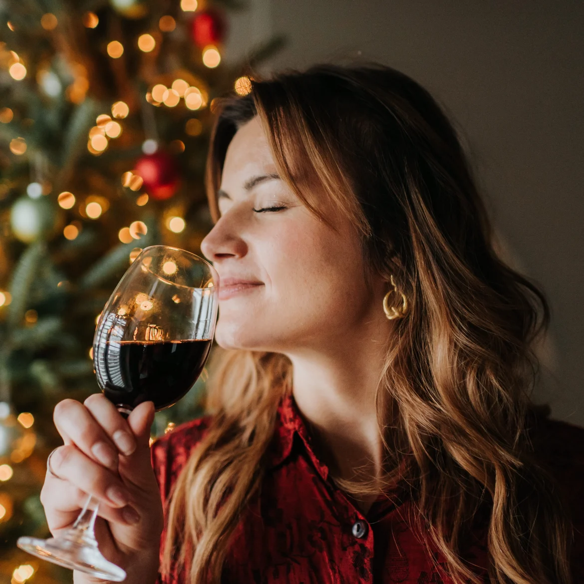 vrouw met wijn voor een kerstboom feestdagen