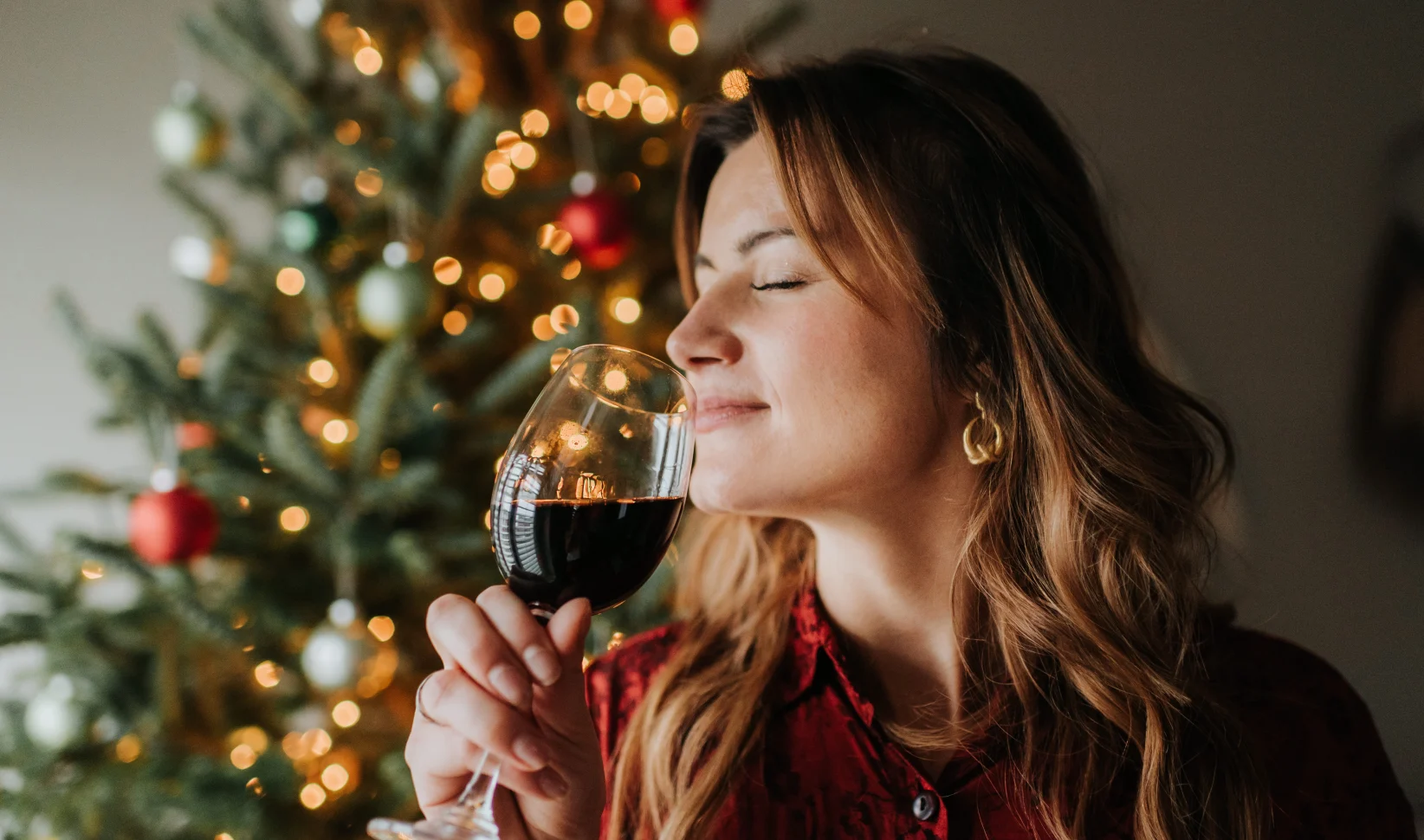 vrouw met wijn voor een kerstboom feestdagen