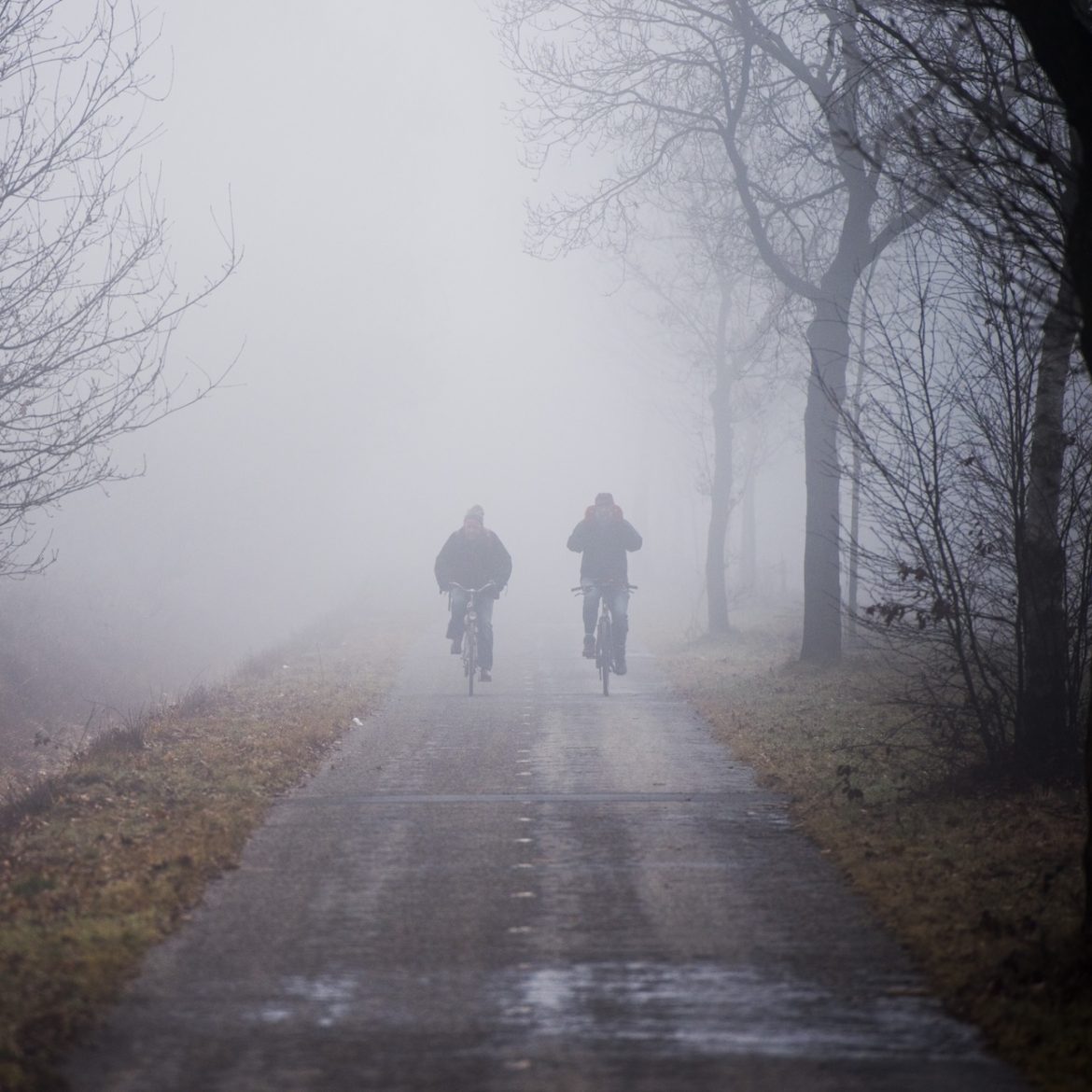 fietsers in dichte mist