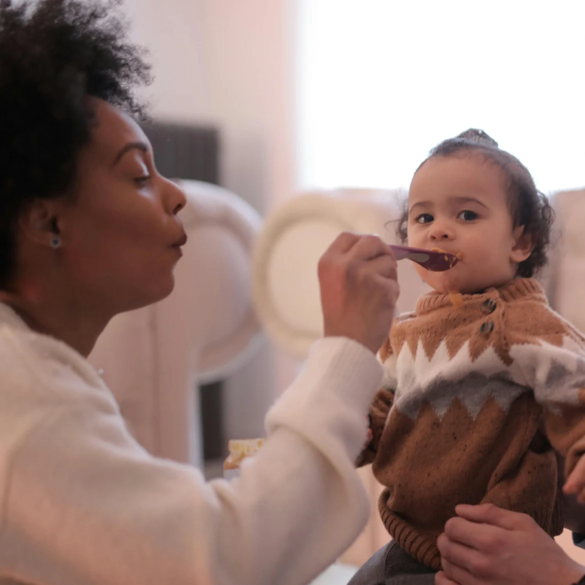 Familie geeft kind te eten Babyvoeding