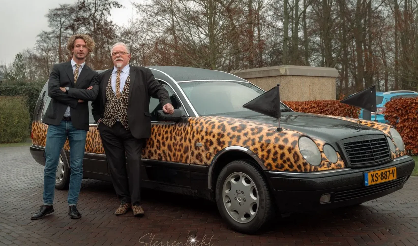 Iede Hoorn en chauffeur bij rouwauto met panterprint